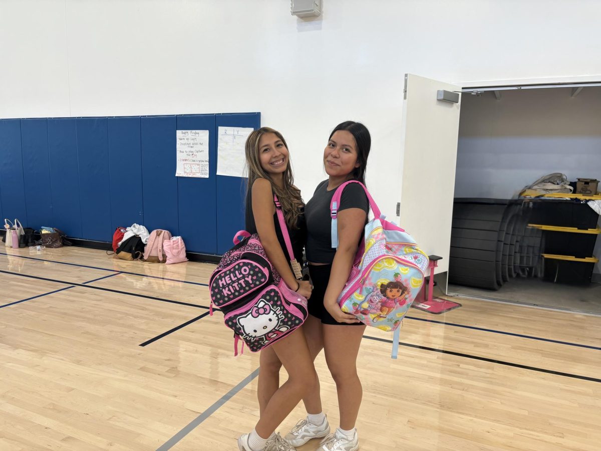 Seniors Elizabeth Merida and Gladys Cuevas with their childhood backpacks 