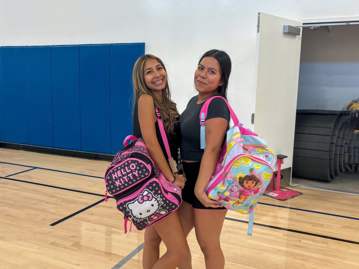 Seniors Elizabeth Merida and Gladys Cuevas show off their childhood backpacks.