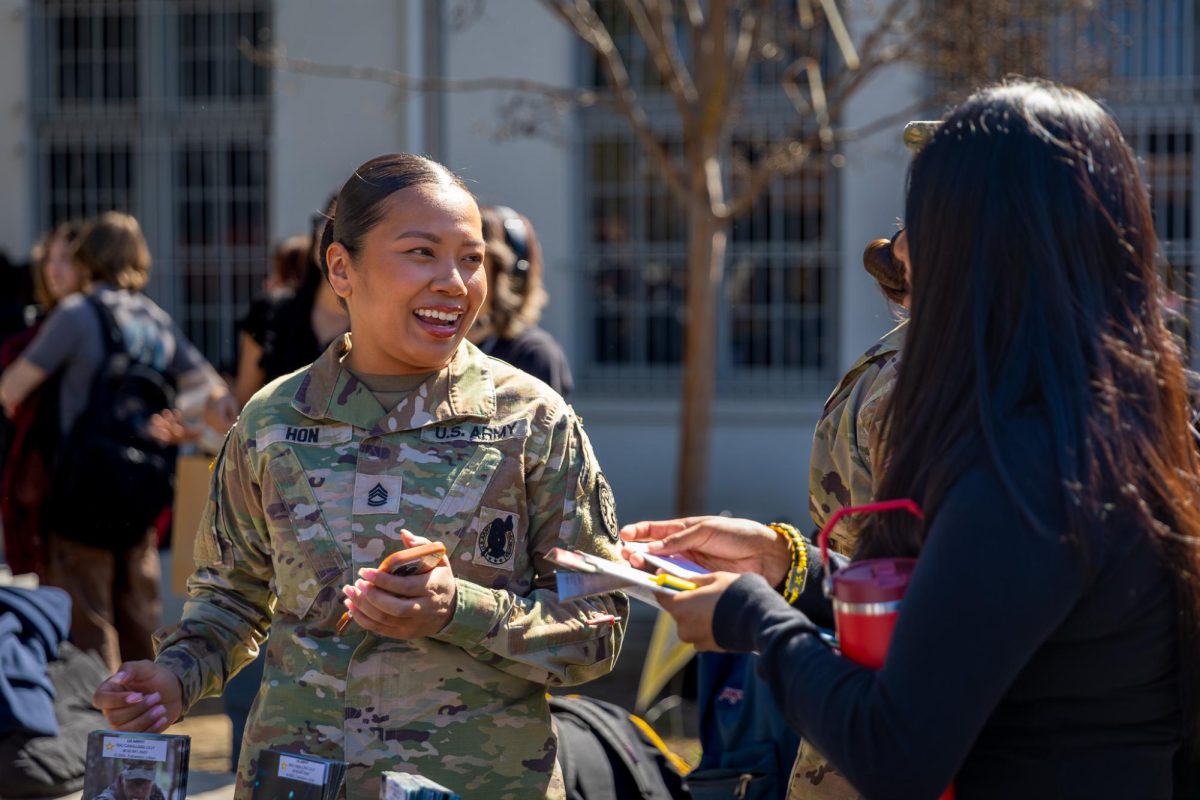 Smiling faces, hidden realities. A recruiter at the career fair on March 6th, presenting the military as a viable option to students.  (Nohohusky)