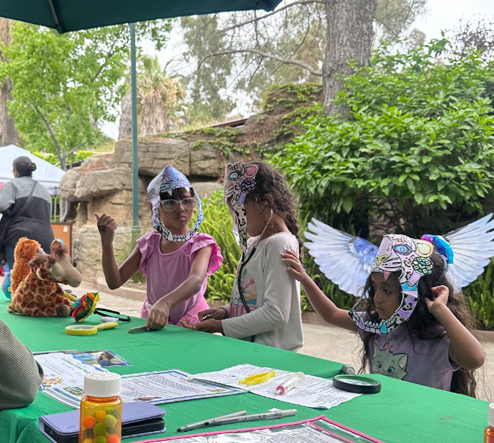 Kids interact at a pretend veterinary table. (Photo by Coral Barriero)