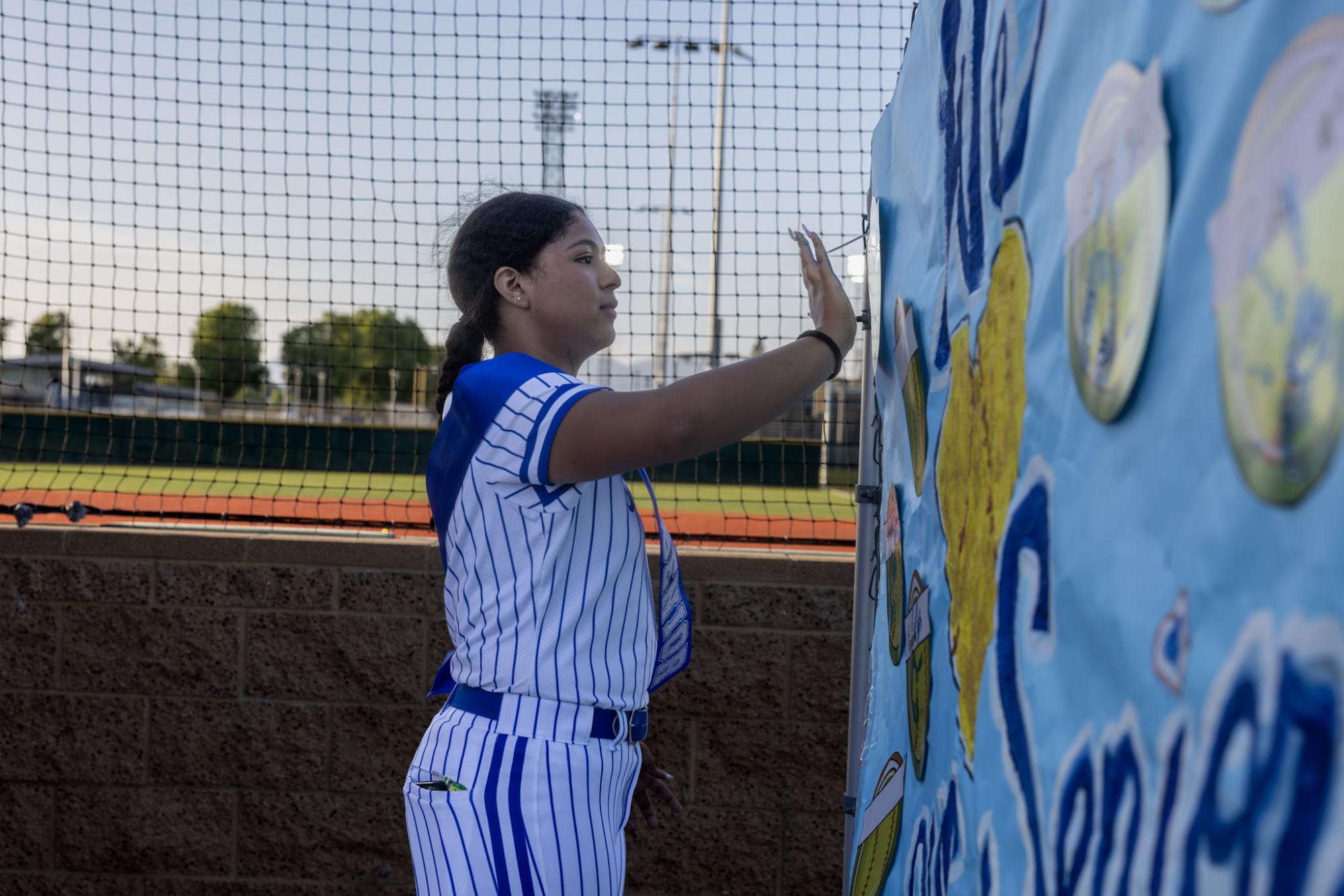 Varsity Softball Senior #9 Miley Bell placing a painted handprint as a bittersweet sign off at senior night hosted at Los Angeles Valley College 